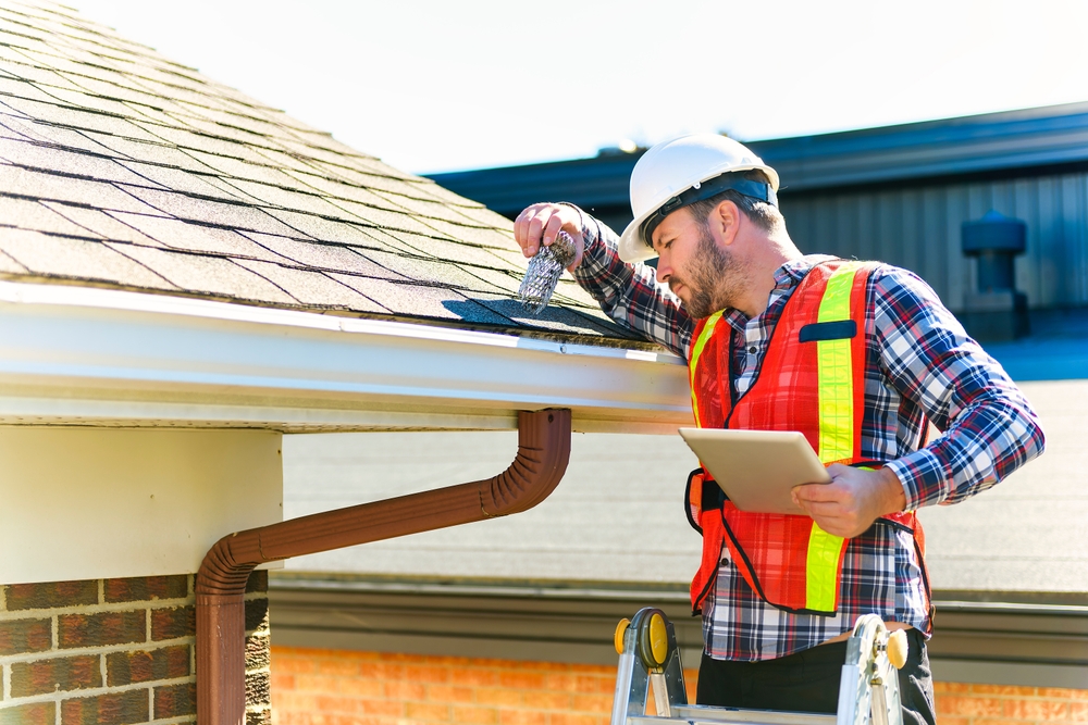 A,Man,With,Hard,Hat,Standing,On,Steps,Inspecting,House